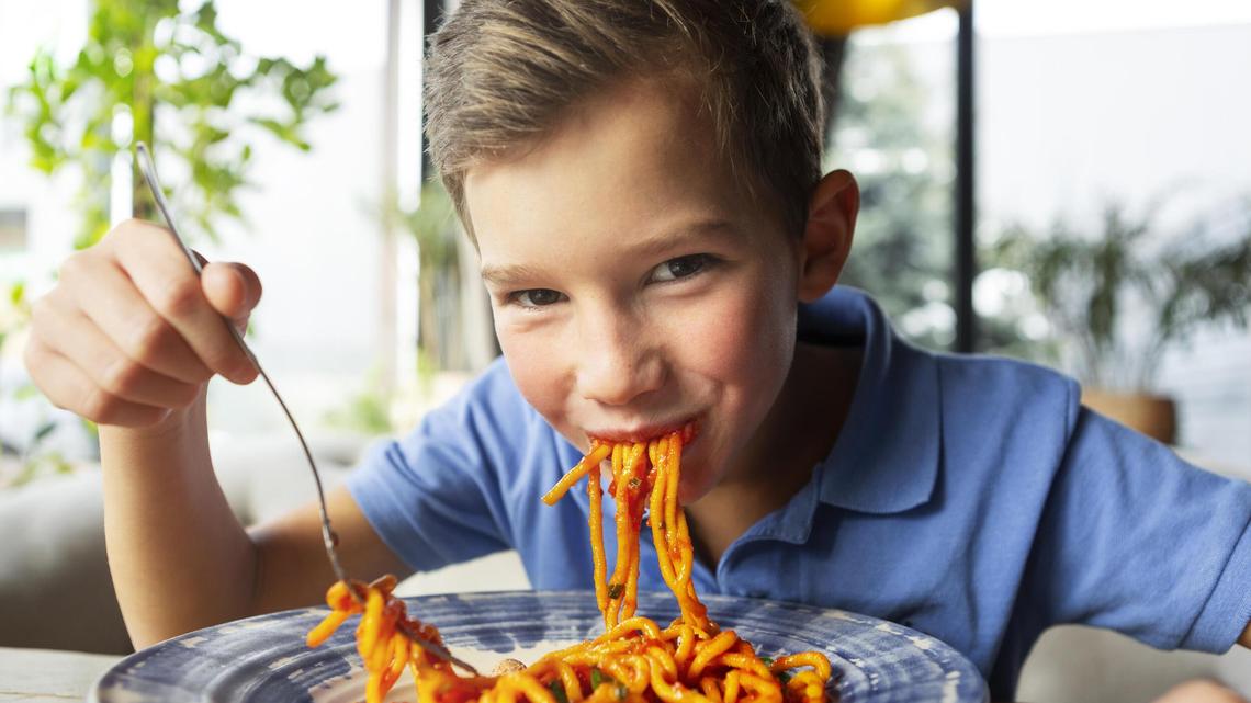 Kind isst Spaghetti.