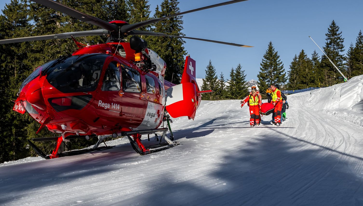 Skifahrer springt über Mauer und streift dabei Frau