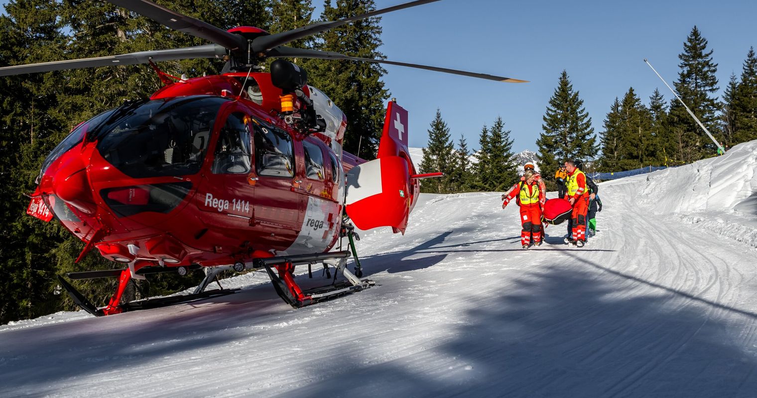 Skifahrer springt über Mauer und streift dabei Frau