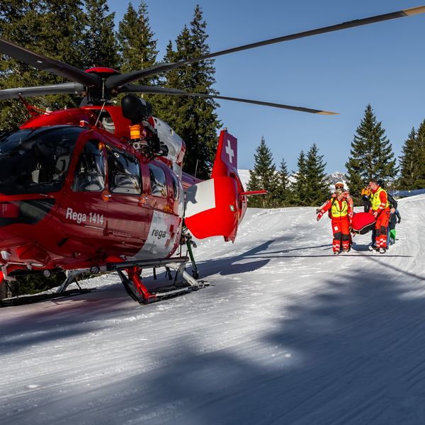 Skifahrer springt über Mauer und streift dabei Frau