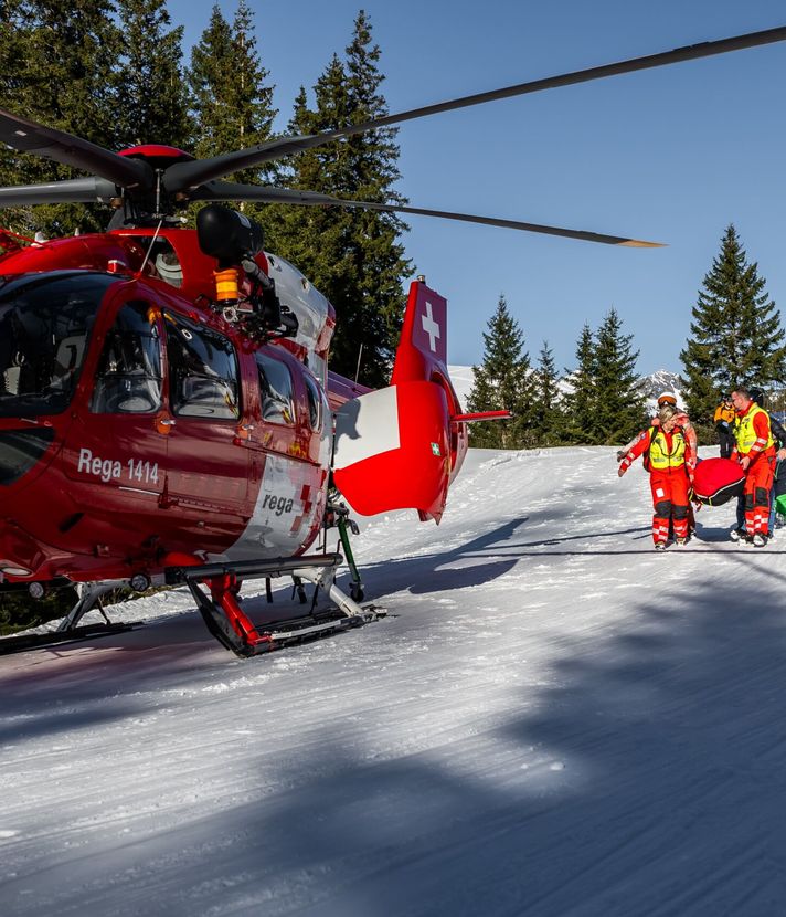 Skifahrer springt über Mauer und streift dabei Frau