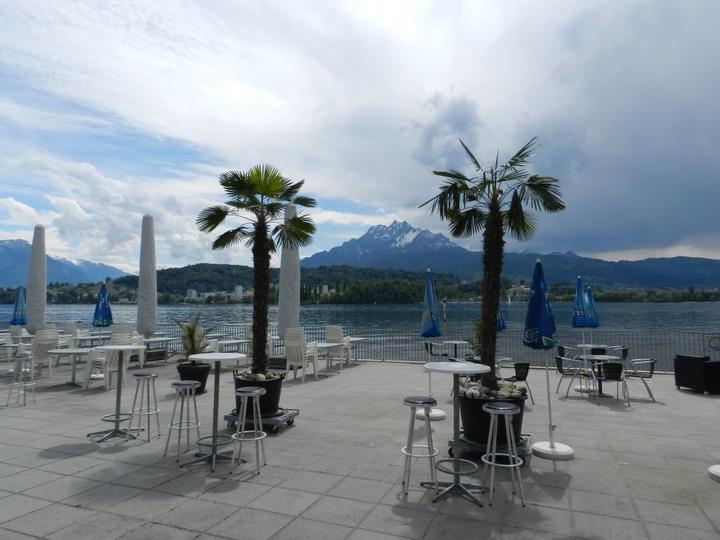 Strandbad Lido: Die grosszügige Restaurant-Terrasse mit Palmen und Blick auf den Pilatus.