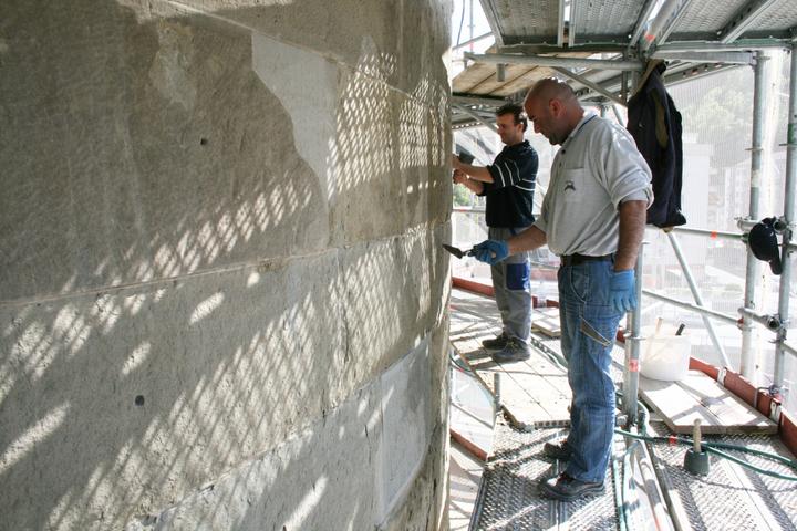Zurzeit sind drei Arbeiter auf der Baustelle mit dem Abklopfen der bröckeligen Fassade beschäftigt.