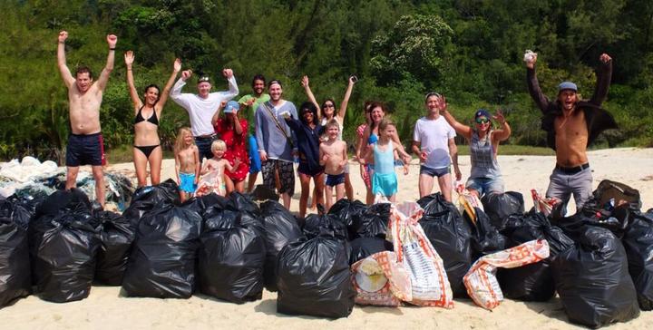 Die Helfer eines wöchentlichen Cleanups feiern das Resultat, bevor der Abfall mit Booten abtransportiert und später auf dem Festland recyclet wird.