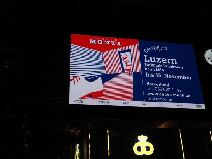 Auf dem Foto eine digitale Werbung aus dem Bahnhof Luzern.