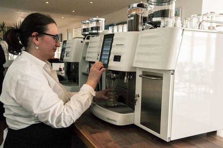 <p>Eine Service-Mitarbeiterin beim Zubereiten von Latte Macchiato.  (Bild: Natalie Ehrenzweig)</p>