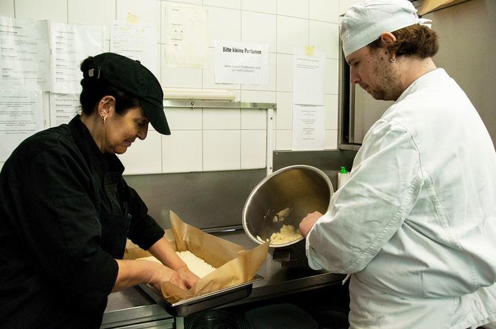 <p>Ursula Imran Al Sous (rechts) beim Zubereiten eines Streuselkuchens mit einem Mitarbeiter.  (Bild: Natalie Ehrenzweig)</p>