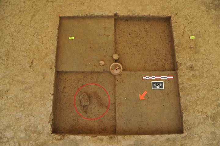 <p>Die Grube von Sursee LU, Hofstetterfeld während der Ausgrabung. Der rote Kreis markiert die Position der beiden Schuhe. Daneben standen drei Gefässe ursprünglich in einer Holzkiste, von ihr sind ebenfalls nur die Nägel übrig geblieben.</p>