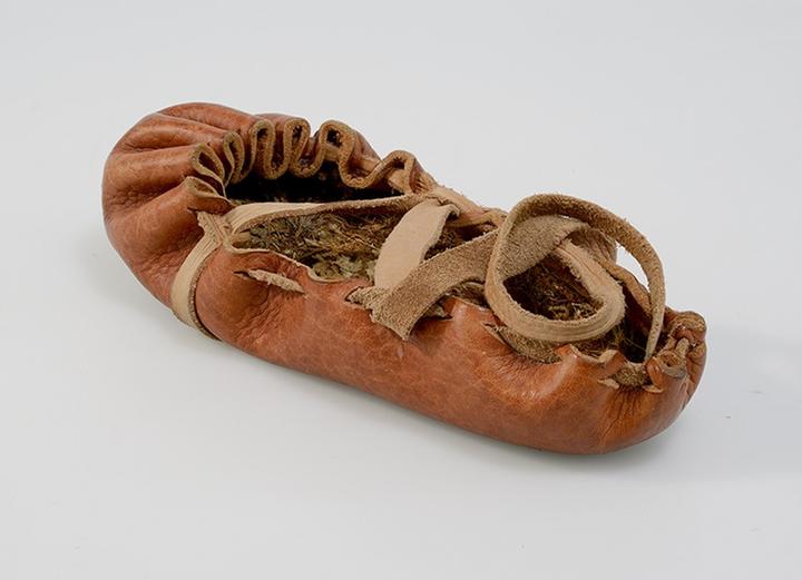 <p>Lederner Bundschuh nach einem Originalfund aus Buinerveen NL (Bronzezeit) mit Einlegesohle aus Moos nach einem Fund aus Zug, Schützenmatt (Jungsteinzeit).</p>