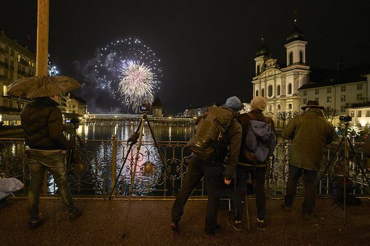 <p>Das Feuerwerk begeisterte auch etliche Fotografen, hier auf der Reussbrücke. (Bild: Emanuel Ammon/AURA)</p>