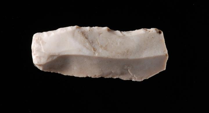 <p>Kleines Feuersteinmesser mit stumpfem Rücken, Teil einer Speerspitze. Um 12’500 v. Chr., Steinhausen ZG, Hinterberg. Bild: Museum für Urgeschichte(n) Zug, Res Eichenberger</p>