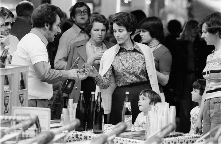 <p>Ein Verkäufer reicht einer Dame ein Gläschen Wein zur Degustation. Bild: Emanuel Ammon/AURA</p>
