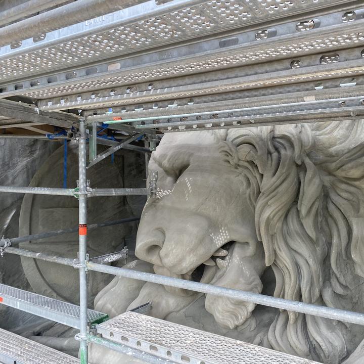 Ein Baugerüst vor dem Löwendenkmal